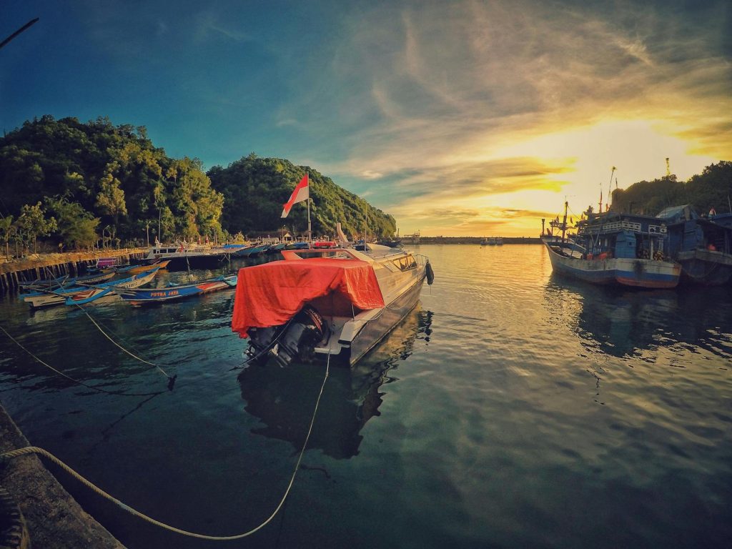 motor boat near dock during sunset