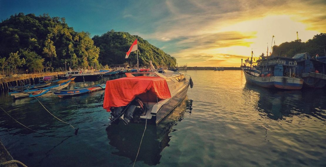 motor boat near dock during sunset